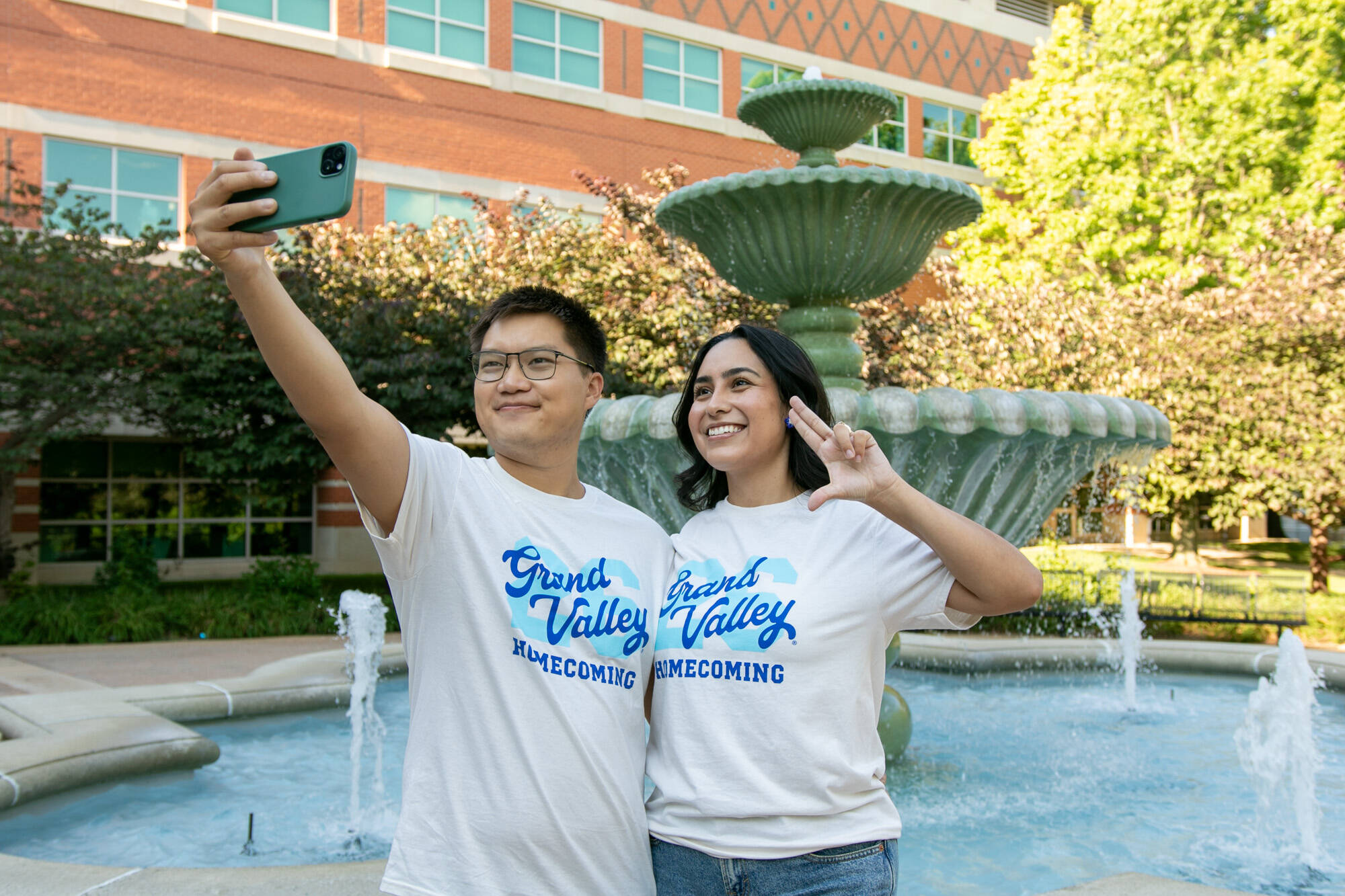 A Laker couple poses for a selfie photo wearing the GVSU Homecoming t-shirt